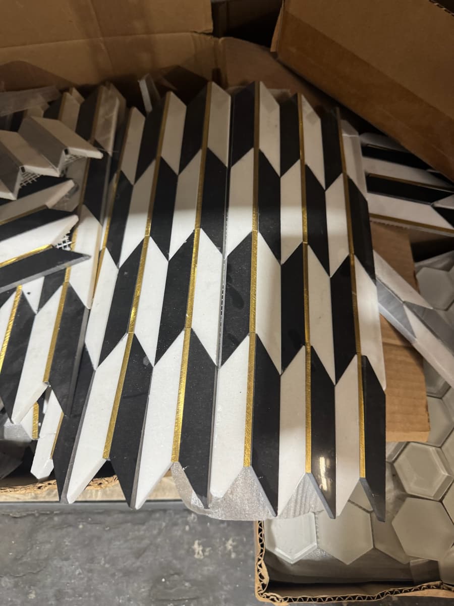 Chevron mosaic tile in black, white and brass